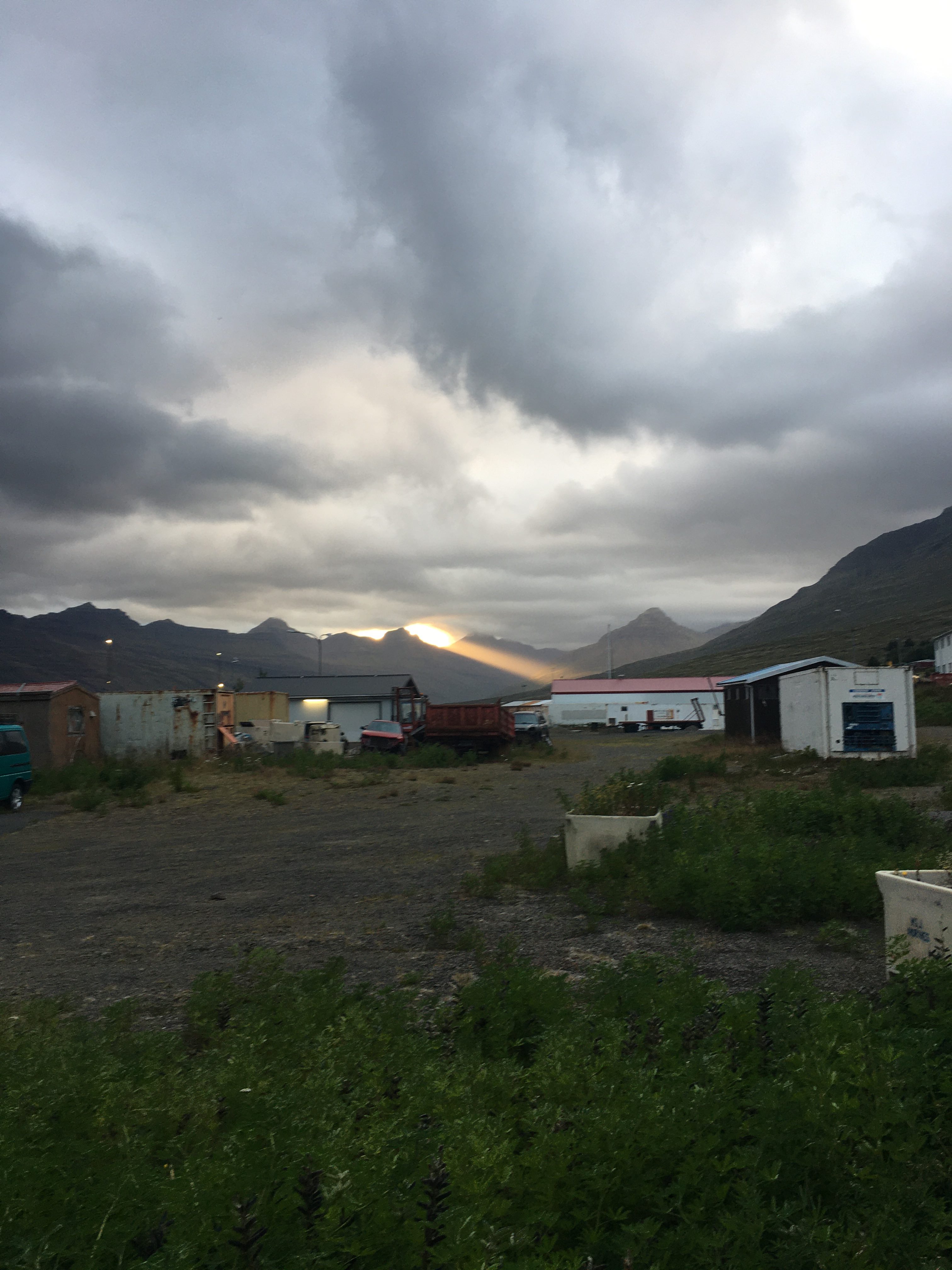 Photograph of some cabins and cars in a dusky, desolate setting